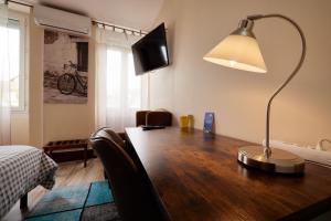 帕米耶hotel de la paix的一张桌子,上面有台灯和一台电视