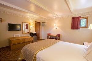 格伦伍德温泉锡达小屋汽车旅馆的配有一张床和一张书桌的酒店客房
