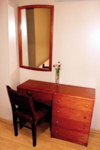 布宜诺斯艾利斯锦绣酒店的木制梳妆台,上面有镜子和花瓶
