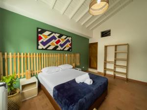 麦德林Hotel Casa Las Palmas的卧室配有一张床,墙上挂有绘画作品