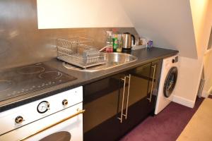 索尔兹伯里Olive Tree 2 bed Apartment - STAYSEEKERS的厨房柜台设有水槽和洗碗机。