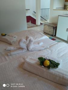 塔尔维西奥Casa Vacanza CADORNA RESIDENCE的床上有毛巾,上面有水果