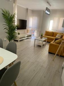 梅利利亚Precioso apartamento a 50 metros de la playa的客厅配有沙发和桌子