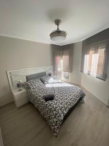 梅利利亚Precioso apartamento a 50 metros de la playa的一间卧室配有一张带黑白色棉被的床