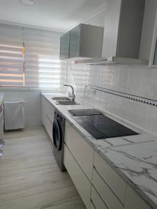 梅利利亚Precioso apartamento a 50 metros de la playa的白色的厨房配有水槽和洗碗机