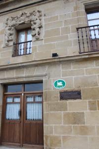 Castañares de RiojaEL REAL DE SIOTA的一座建筑,设有两扇木门和两扇窗户
