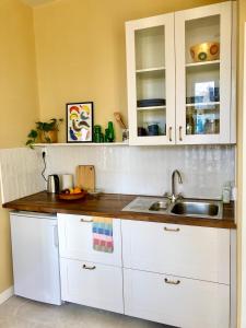 孙讷FärgLabbets Bed and Breakfast的厨房配有白色橱柜和水槽