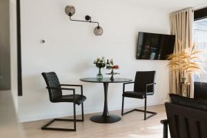 巴勒哈姆斯泰德Appartement De Torenhoeve NIEUW的餐桌,配有两把椅子和一盏灯