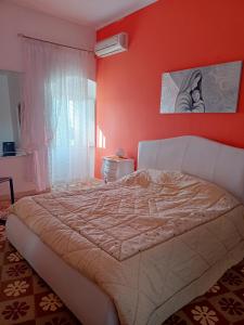PomaricoLa casetta的一间卧室配有一张带橙色墙壁的大床