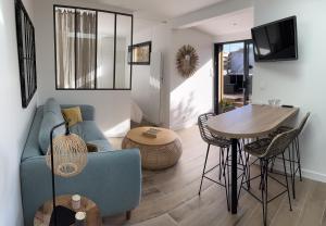 拉蒂尔巴勒Lodge LE CABANON accès direct plage !的客厅配有蓝色的沙发和桌子