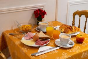 皮托Hôtel Princesse Isabelle的一张桌子,上面有早餐食品和饮料