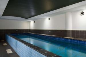 麦凯日吉尔斯麦凯套房酒店的客房内的大型游泳池,有蓝色的水