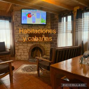 奇格纳瓦潘Hotel y Cabañas Alan的客厅设有壁炉和墙上的电视