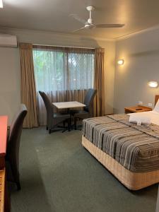 凯恩斯大炮公园汽车旅馆的酒店客房带一张床、一张桌子和椅子