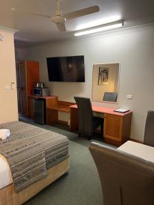 凯恩斯大炮公园汽车旅馆的配有一张床和一张书桌的酒店客房