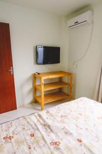帕罗卡Morada do Mar Aberto - 100 metros da praia的一间卧室配有一张床和一台平面电视