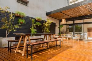 布宜诺斯艾利斯La Casa de Bulnes的墙上有长椅和植物的用餐室