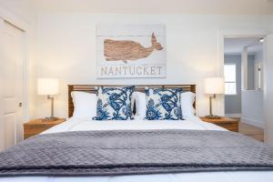 半月湾Nantucket Penthouse - walk to restaurants beaches activies & so much more的一间卧室配有一张带蓝色和白色枕头的床