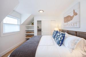 半月湾Nantucket Penthouse - walk to restaurants beaches activies & so much more的一间卧室配有一张带蓝白色枕头的大床