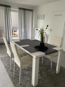 格拉德贝克Modernes Appartement的餐桌和椅子,上面有植物