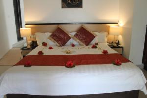劳托卡Lander's Bay Resort的一间卧室配有一张红色鲜花的大床