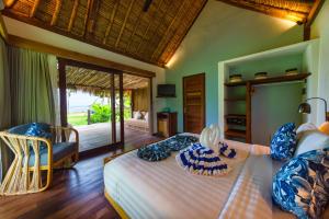 塞隆贝拉纳克Segara Lombok Beach Resort的一间卧室,卧室内配有一张床和一把椅子