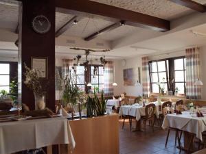 巴特索登-萨尔明斯特Landgasthof Zum Jossatal的一间带桌椅和时钟的用餐室