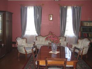 库塔伊西Guesthouse Gegi的一间带桌椅和2扇窗户的用餐室