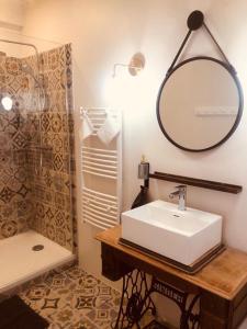 莫雷卢安河Hôtes de Maïa Chambre d'hôtes的一间带水槽、镜子和淋浴的浴室