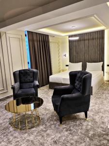 萨拉热窝Hotel Boutique Bristol的酒店客房配有一张床、两把椅子和一张桌子