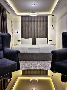 萨拉热窝Hotel Boutique Bristol的一间卧室配有一张床、两把椅子和一张桌子