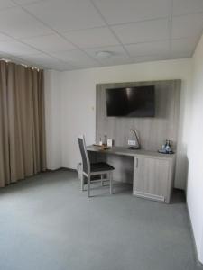 斯图加特斯图加特-维辛根商务酒店及公寓的一间房间,配有一张桌子和一台墙上的电视
