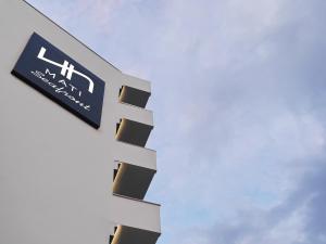 马蒂NLH Mati Seafront - Neighborhood Lifestyle Hotels的建筑物一侧的标志