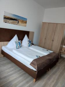 博尔库姆博尔库姆诺德希酒店的一张带白色床单和蓝色枕头的床
