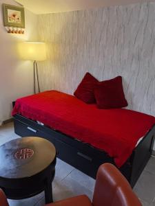 Saint-Julien-sur-CalonneObungalow de July Belle vue的一间卧室配有一张带红色床单的床和一把椅子