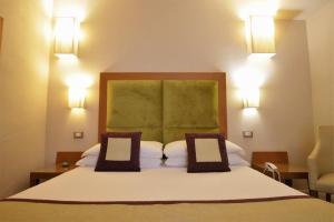 佛罗伦萨佩尔塞奥酒店的一间卧室配有一张大床和两个枕头