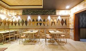 古瓦哈提Treebo Trend Apollo的一间在房间内配有桌子和凳子的餐厅