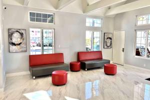 安纳海姆Ramada by Wyndham Anaheim Convention Center的客厅配有两把椅子和红色座椅