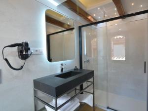 托莱多Hospedium Hotel Posada de la Silleria的一间带黑色水槽和淋浴的浴室