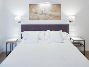 托莱多Hospedium Hotel Posada de la Silleria的一间卧室配有白色床和2个床头柜