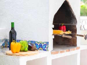 卡尔佩Holiday Home La Cigarra by Interhome的柜台上的一瓶葡萄酒和一些蔬菜