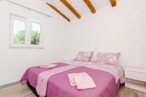 西利皮Apartments Dubrovnik Airport的白色卧室配有一张带粉红色床单的大床