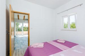 西利皮Apartments Dubrovnik Airport的一间卧室配有一张紫色的床和镜子