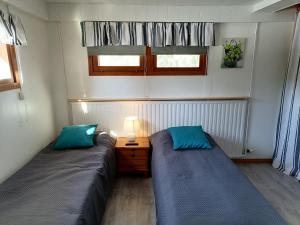 TaipalsaariHostel Mansikka的小客房内的两张床,配有蓝色枕头