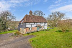 Horsted KeynesBellflower Cottage, Ashdown Forest的田野中的一座老房子,有车道