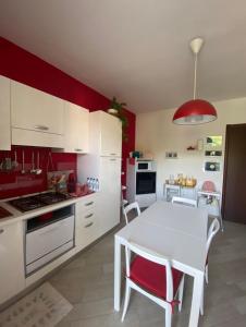 CossatoDa Felicia的厨房配有白色桌子和红色墙壁