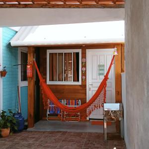 弗洛里亚诺波利斯Tiny House moçambique - Sua casinha em Floripa!的房屋前带橙色吊床的门廊
