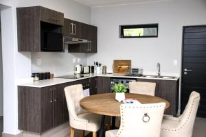 约翰内斯堡“Pop Inn” modern apartment in heart of Bryanston的一个带木桌和椅子的小厨房
