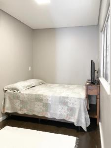 SiderópolisContainer na montanha的一间卧室配有一张床和一张桌子上的电视