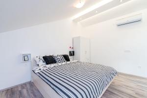 杜布罗夫尼克Bovolini's Place的白色卧室配有一张黑白条纹大床